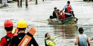Rettungskräfte in einem Rettungsboot evakuieren Menschen