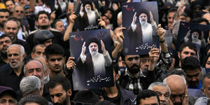 Menschenmassen auf Teherans Straßen halten Schilder mit dem Bild Ebrahim Raisis hoch