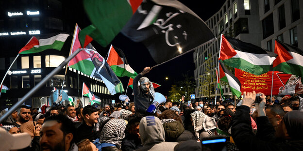Demonstranten schwenken palästinensische nd islamistische Fahnen