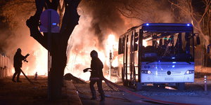 ein Bus, zwei Feuerwehrmänner und Flammen