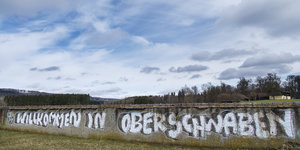 Ein Graffito auf einer Mauer unter blauem Himmel