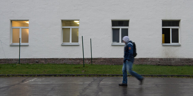 Ein Mann läuft vor einem Gebäude lang