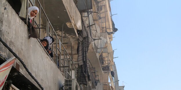 Zwei Frauen gucken von einem Balkon in Aleppo