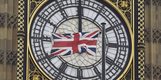 Ein Union Jack verdeckt das Ziffernblatt einer Uhr am Glockenturm des Big Ben