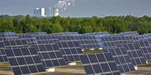 Photovoltaikanlage, im Hintergrund Kühltürme
