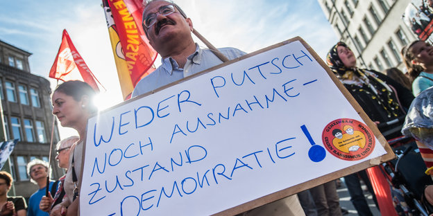 Ein mann hält ein Schild mit der Aufschrift: „Weder Putsch noch Ausnahmezustand – Demokratie!“