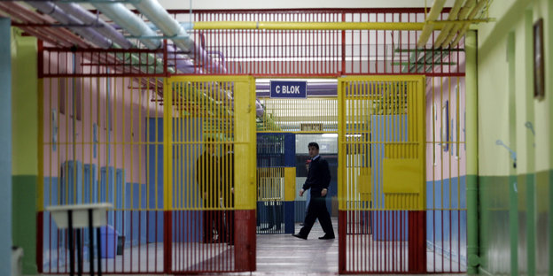 Ein Gefängnisflur mit bunten Gittern