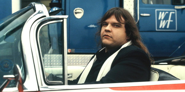 ein langhaariger Mann, Meat Loaf, in einem Amischlitten aus den 50ern ein langhaariger Mann, Meat Loaf, in einem Amischlitten aus den 50ern