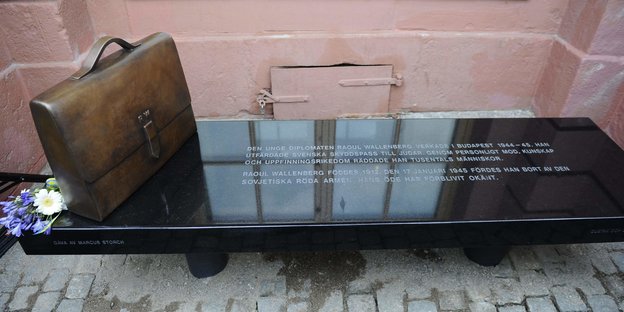 Eine Bank mit bronzener Brieftasche vor dem schwedischen Außenministerium in Stockholm in Gedenken an Wallenberg