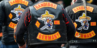 Die Rücken von drei Bandidos-Mitglieder tragen das Bandidos-Logo