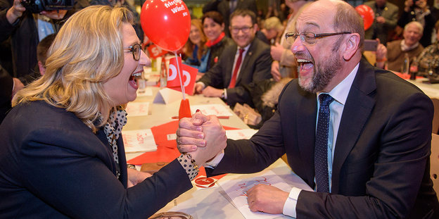 Anke Rehlinger und Martin Schulz geben sich lachend die Hand an einem langen Tisch bei einer Veranstaltung Anke Rehlinger und Martin Schulz geben sich lachend die Hand an einem langen Tisch bei einer Veranstaltung