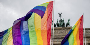 Das Brandenburger Tor mit davor wehenden Regenbogen-Fahnen