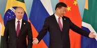 Zei Männer vor den Flaggen der BRICS-Staaten