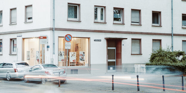Autos fahren vor einem Haus entlang Autos fahren vor einem Haus entlang