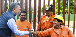Mauricio Macri schüttelt dem einem Arbeiter die Hand