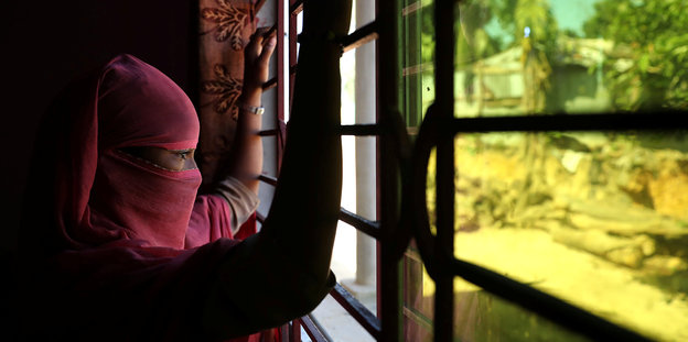 Ein Rohingya-Mädchen blickt durch ein Fenster