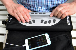 Jemand tippt auf einer Braillezeile, sie ist an ein Smartphone angeschlossen Jemand tippt auf einer Braillezeile, sie ist an ein Smartphone angeschlossen