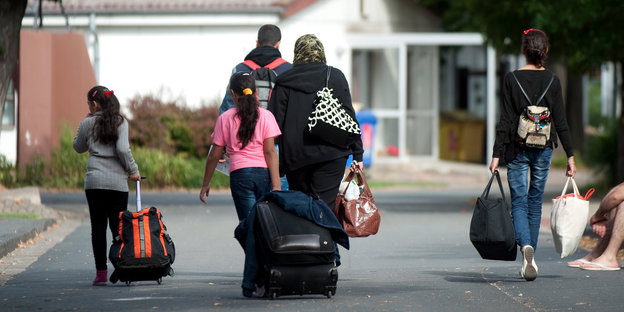 Fllüchtlinge mit Koffern und Tüten in Friedland