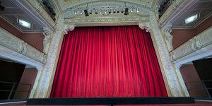 Die Bühne des Mecklenburgischen Staatstheaters ist mit einem roten Vorhang vollständig verhüllt.