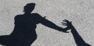 der Schatten einer Person, die eine Hand abwehrt