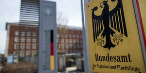 Ein Gebäude und davor ein Schild mit dem Bundesadler und der Aufschrift Bundesamt für Migration und Flüchtlinge