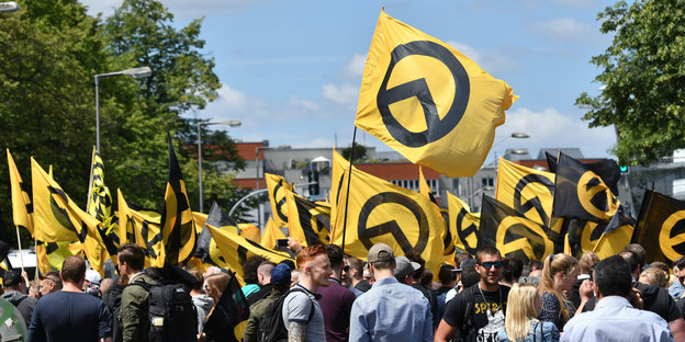Eine Menschenmenge trägt gelbe Flaggen