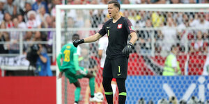 Polens Torhüter Wojciech Szczesny beschwert sich bei den Teamkollegen, während im Hintergrund gerade M'Baye Niang zum Torschuss ansetzt.