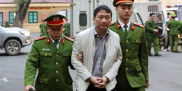 Der angeklagte Geschäftsmann Trinh Xuan Thanh wird von Polizisten zu einem Gericht in Hanoi (Vietnam) gebracht
