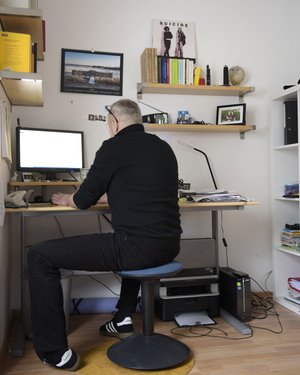 Ein Mann sitzt an seinem Schreibtisch vor seinem Rechner Ein Mann sitzt an seinem Schreibtisch vor seinem Rechner