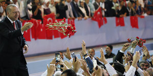 Der türkische Präsident Erdogan wirft einer Menschenmenge Rosen zu