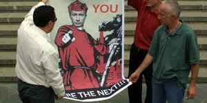 Drei Männer halten ein Plakat, auf dem Putin und der Schriftzug "Georgien 2008 - you are the next" abgebildet ist