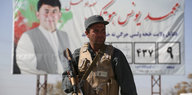 Vor einem Checkpoint in Kabul steht ein bewaffneter Polizist