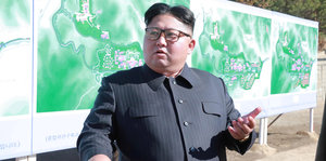 Der Nordkoreanische Machthaber Kim Jong Un vor einer Plakatwand.