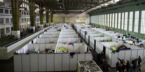 Im ehemaligen Flughafen Tempelhof stehen Doppelstockbetten in einem Hangar