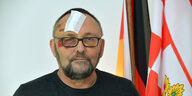 Frank Magnitz sitzt mit Pflaster und Verletzungen am Auge in einem Bremer AfD-Büro.