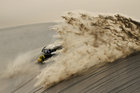 Ein Motorradfahrer fällt bei der Rally Dakar hin