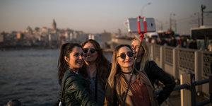 Junge Frauen stehen am Goldenen Horn in Istanbul und machen ein Selfie