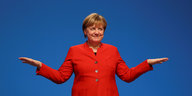 Merkel im roten Kostüm breitet ihre Arme aus