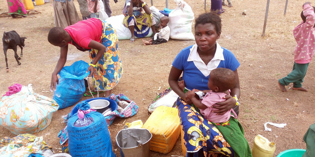 Die aus dem Kongo geflohene Aliet Makyosi sitzt mit ihrem Kind neben einem Blecheimer.