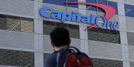 Ein Mann geht an einem Gebäude mit dem Schriftzug von Capital One vorüber