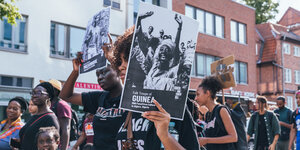 Schwarze Frauen demonstrieren mit Schildern gegen Femizid