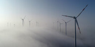 Mehrere Windkrafträder im Nebel