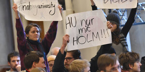 Studierende halten Plakate für André Holm hoch