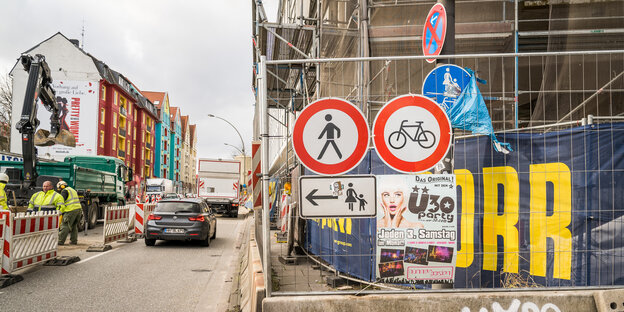 Baustelle, am Bauzaun Verbotsschilder für Fußgänger und Radfahrer, links Autoverkehr