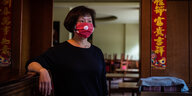 Eine Frau steht mit Maske in einem Restaurant