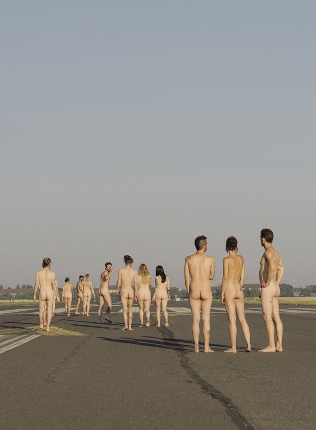 Eine Gruppe von Frauen und Männern steht nackt auf dem Tempelhifer Feld für eine Kunstaktion