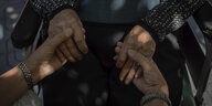 Jüngere Frau hält Hände einer älteren Frau