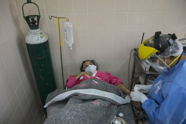 Eine junge Frau liegt in einem Krankenhausbett und ist an einen Tropf angeschlossen.
