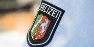 Ein Abzeichen der nordrhein-westfälischen Polizei, fotografiert auf einem Hemd in der Landesleitstelle der Polizei