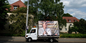 Pritschenwagen mit Werbung für Pegida-Kandidatin auf einer Straße.